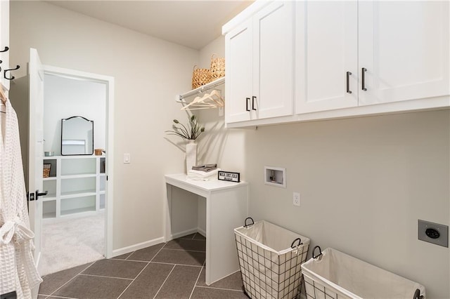washroom featuring hookup for an electric dryer, baseboards, hookup for a washing machine, cabinet space, and dark tile patterned floors