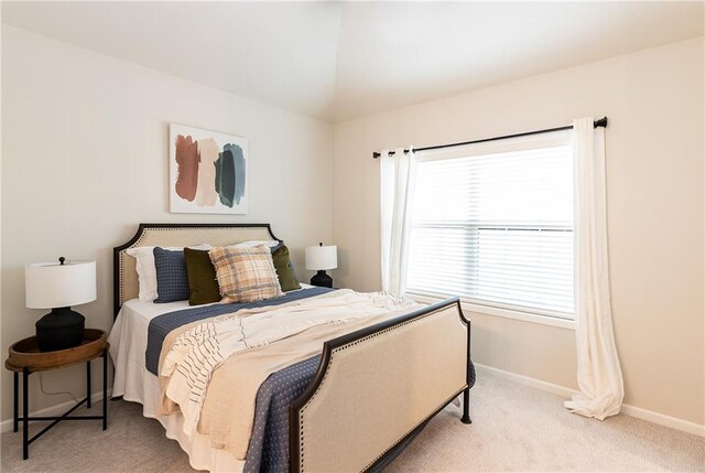 bedroom with multiple windows, vaulted ceiling, carpet, and baseboards