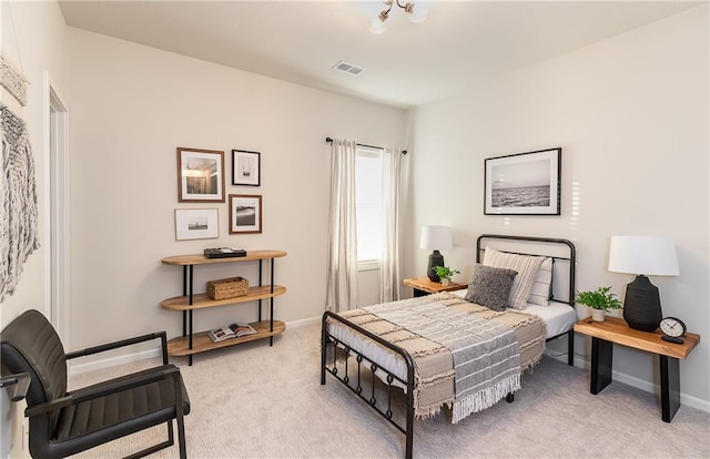 bedroom featuring baseboards, visible vents, and light colored carpet