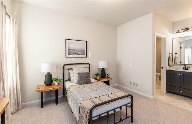 bedroom featuring baseboards, visible vents, light colored carpet, and a sink