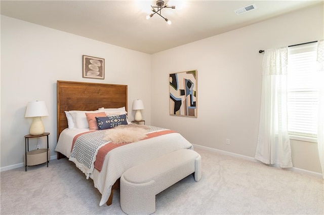 bedroom featuring light carpet and an inviting chandelier