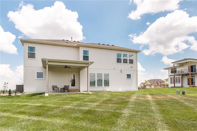 rear view of house featuring a lawn, a ceiling fan, central AC unit, and a patio area
