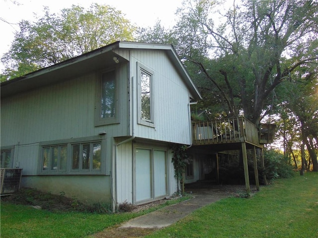 view of home's exterior featuring central AC, a deck, and a yard