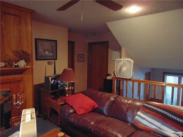 living room with ceiling fan, a textured ceiling, and vaulted ceiling