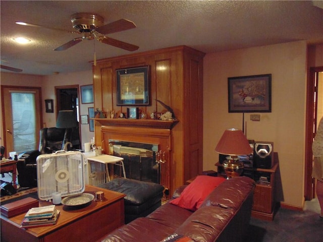 carpeted living room featuring ceiling fan and a textured ceiling