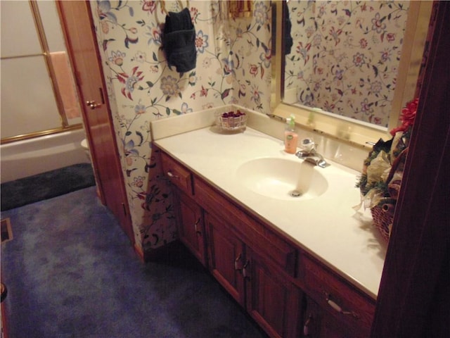 bathroom featuring large vanity and enclosed tub / shower combo