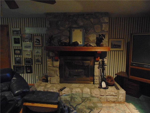 living room with ceiling fan and a fireplace