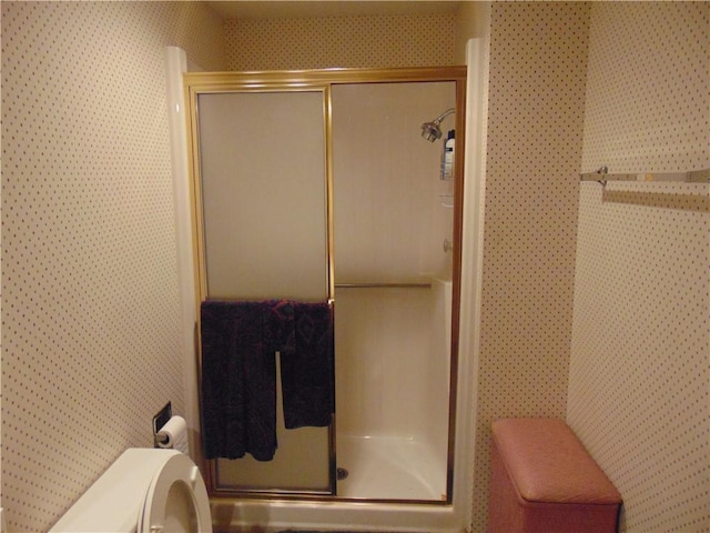 bathroom with toilet and a shower with shower door