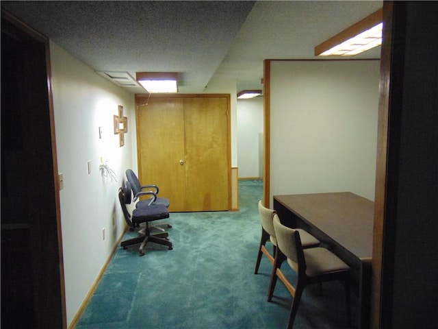 interior space featuring a textured ceiling and dark carpet