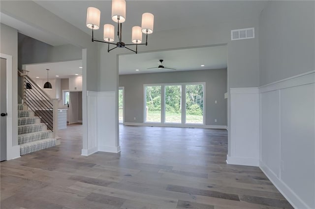 spare room featuring light hardwood / wood-style floors and ceiling fan with notable chandelier