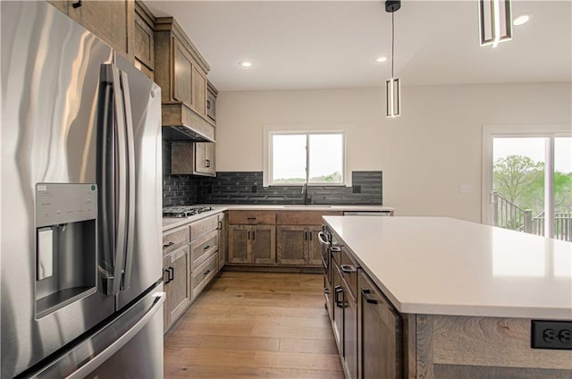 7551 NW Gower Ave, Kansas City, MO 64151 - kitchen featuring light countertops, appliances with stainless steel finishes, decorative backsplash, and light wood-type flooring