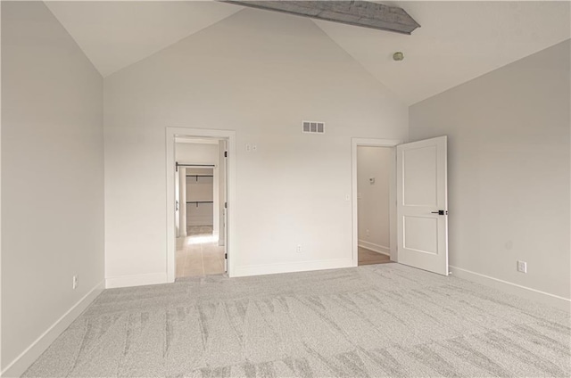 7551 NW Gower Ave, Kansas City, MO 64151 - spare room with baseboards, visible vents, carpet floors, and high vaulted ceiling