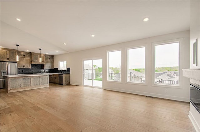 7551 NW Gower Ave, Kansas City, MO 64151 - kitchen featuring stainless steel fridge, light wood-style floors, and backsplash