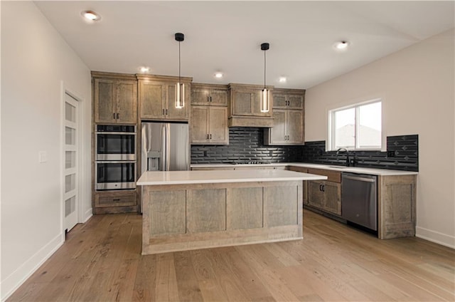 7551 NW Gower Ave, Kansas City, MO 64151 - kitchen with stainless steel appliances, light wood-style floors, decorative backsplash, a kitchen island, and light countertops