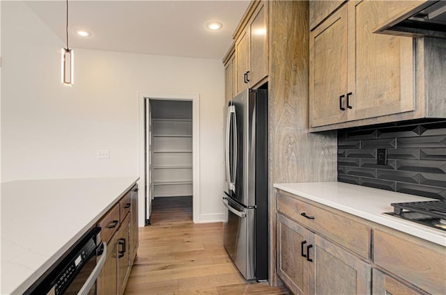 7551 NW Gower Ave, Kansas City, MO 64151 - kitchen featuring tasteful backsplash, recessed lighting, hanging light fixtures, freestanding refrigerator, and light wood-type flooring