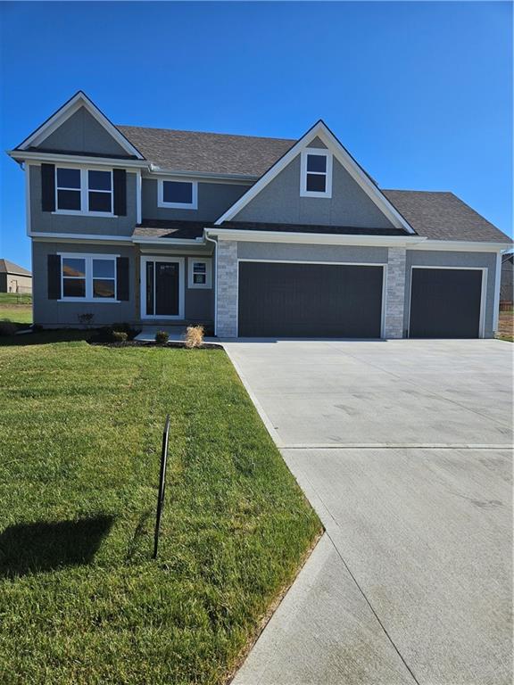 view of front of property featuring a front lawn and a garage