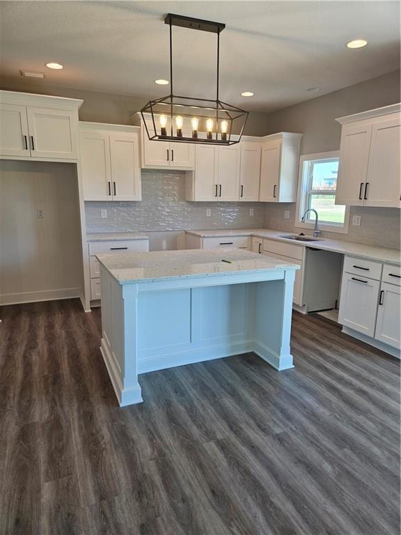 kitchen featuring pendant lighting, white cabinets, a kitchen island, and dark wood-type flooring