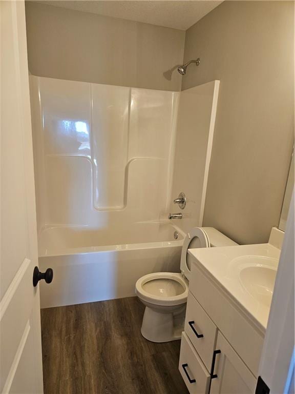 full bathroom with vanity, shower / washtub combination, hardwood / wood-style floors, and toilet