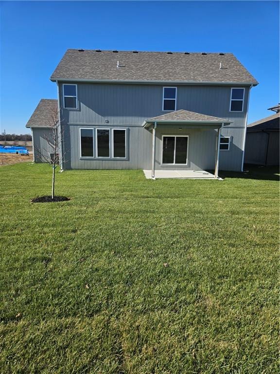 rear view of property featuring a yard and a patio area