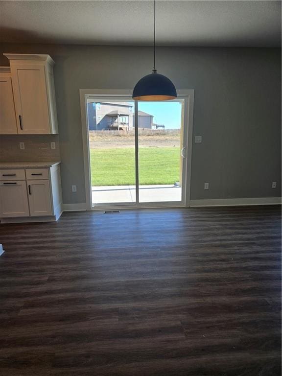 unfurnished dining area with dark hardwood / wood-style flooring