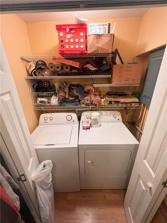 clothes washing area featuring hardwood / wood-style flooring and washing machine and dryer