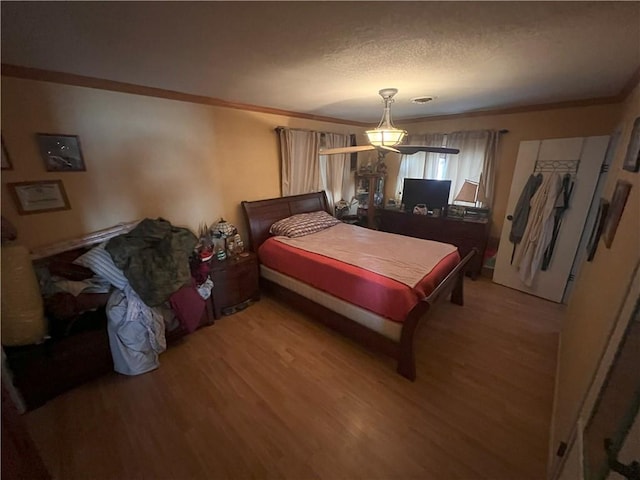 bedroom featuring hardwood / wood-style flooring and crown molding