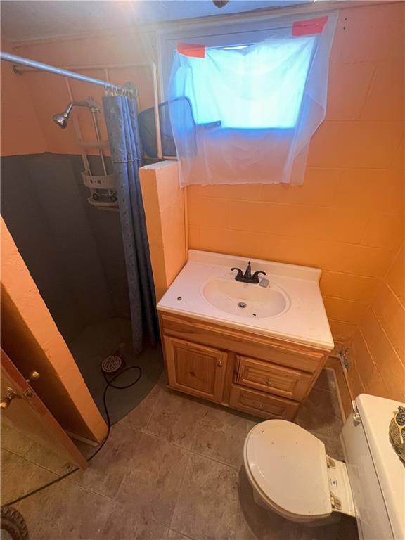 bathroom with vanity, tile patterned flooring, toilet, and tile walls