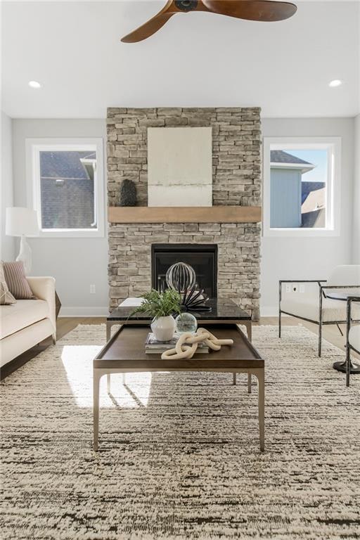 living room featuring hardwood / wood-style flooring, a fireplace, and ceiling fan