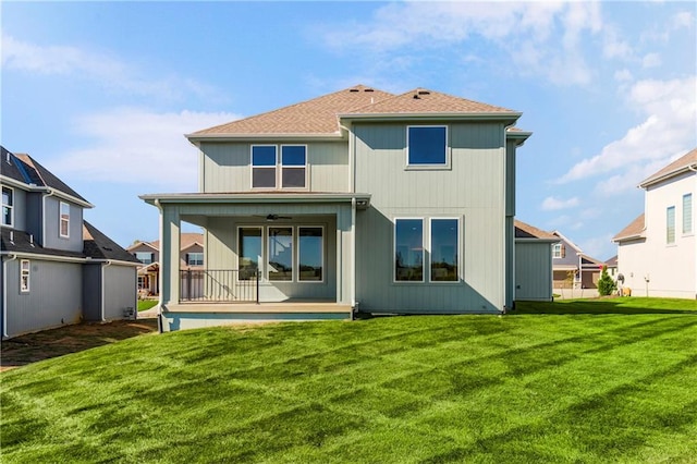 back of property featuring a yard and ceiling fan