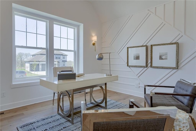 home office with light hardwood / wood-style floors and vaulted ceiling