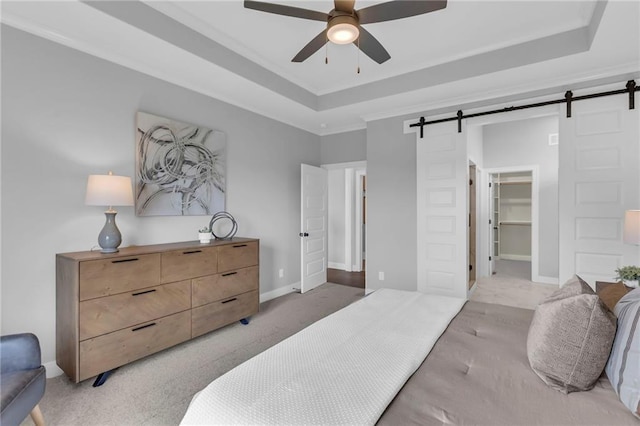 16879 S Cardinal St, Olathe, KS 66062 - bedroom featuring a barn door, a raised ceiling, baseboards, a walk in closet, and ornamental molding