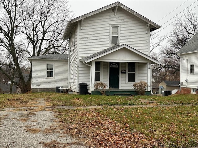 view of front facade featuring a porch, a front lawn, and cooling unit