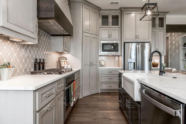 kitchen featuring hanging light fixtures, premium range hood, stainless steel appliances, gray cabinets, and dark hardwood / wood-style floors