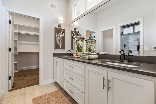 bathroom with vanity, a shower with door, and wood-type flooring