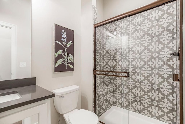 bathroom featuring vanity, an enclosed shower, and toilet