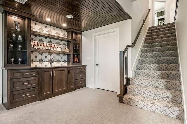 bar featuring sink, light carpet, dark brown cabinets, and wooden ceiling