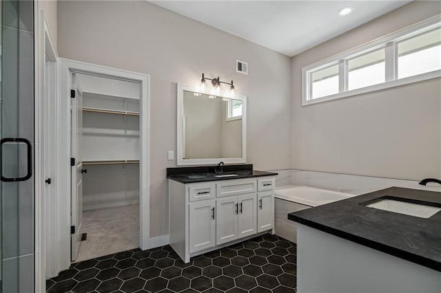 bathroom featuring separate shower and tub and vanity