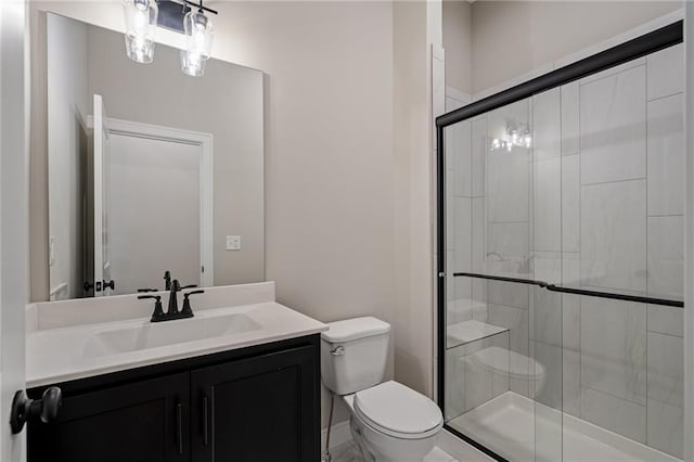 bathroom featuring toilet, vanity, and walk in shower