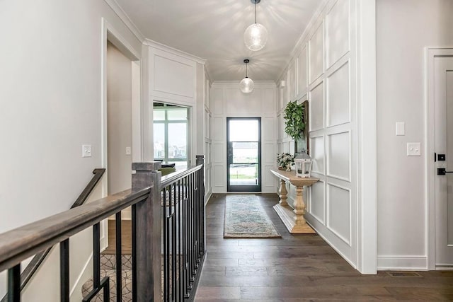 entryway with dark hardwood / wood-style flooring and ornamental molding