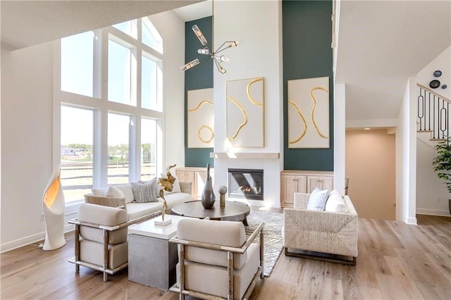 living room featuring a towering ceiling and light hardwood / wood-style floors