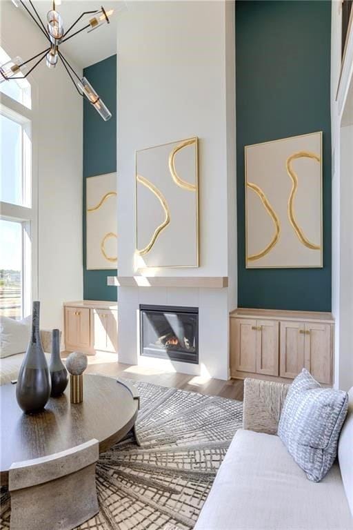 living room featuring a notable chandelier, hardwood / wood-style flooring, and a high ceiling