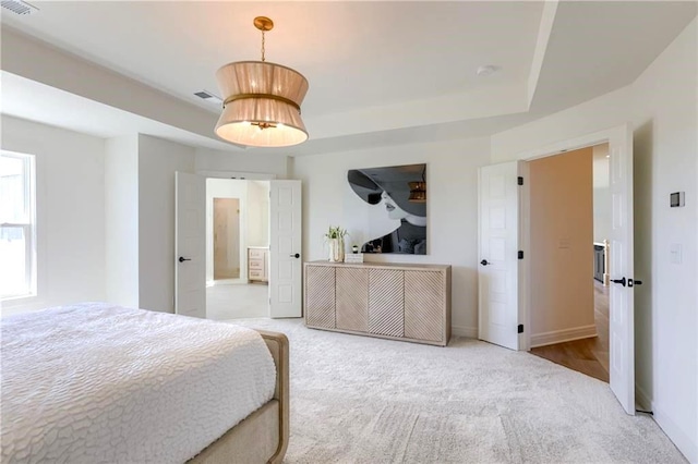 bedroom featuring a raised ceiling and carpet flooring