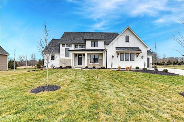 modern farmhouse featuring a porch and a front yard