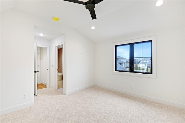 carpeted empty room featuring vaulted ceiling