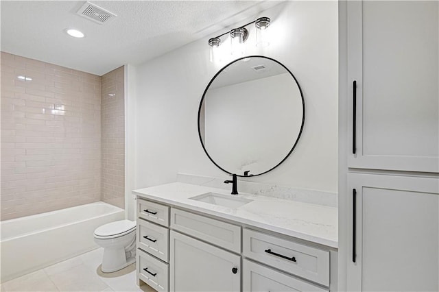 full bathroom featuring toilet, a textured ceiling, vanity, tiled shower / bath combo, and tile patterned flooring