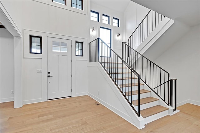 foyer with light hardwood / wood-style floors and a high ceiling