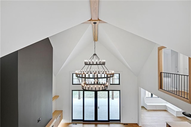 interior space featuring a notable chandelier, beam ceiling, and wood-type flooring