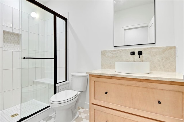 bathroom featuring tasteful backsplash, vanity, walk in shower, and toilet