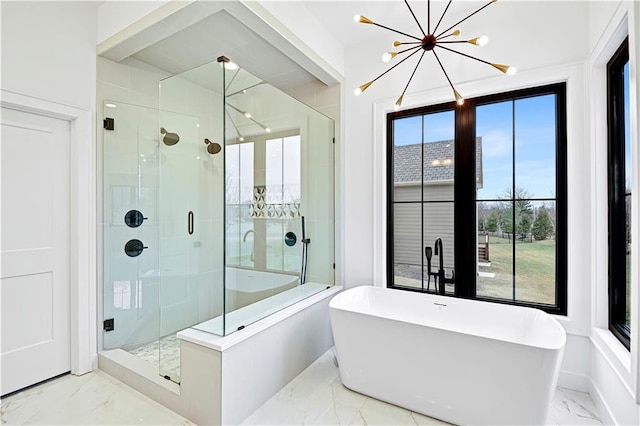 bathroom featuring independent shower and bath and an inviting chandelier