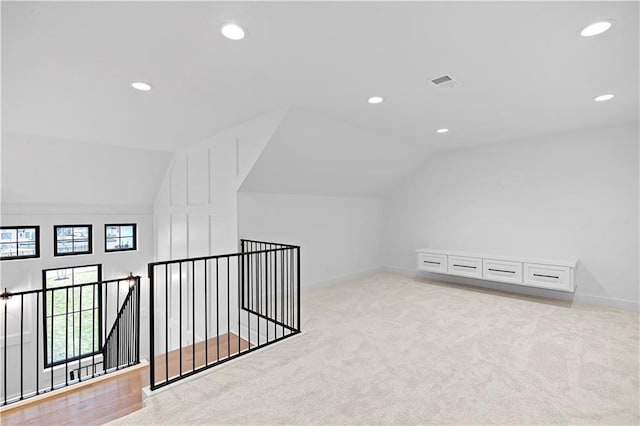 bonus room with light colored carpet and lofted ceiling